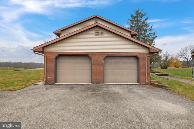 a front view of house with yard and garage