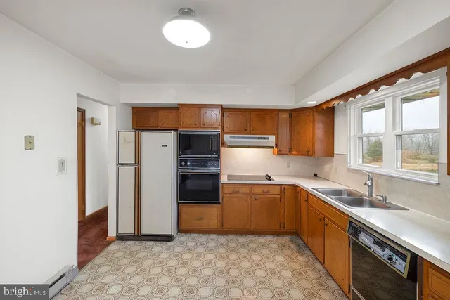 a kitchen with a sink cabinets stainless steel appliances and a window