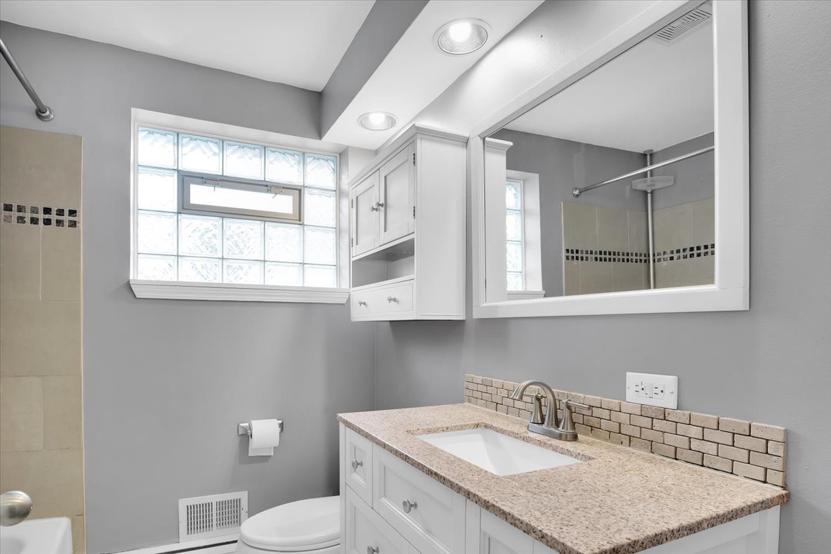 10822 Major Avenue Chicago Ridge, IL 60415 - Photo 14 of 30 a bathroom with a granite countertop sink mirror and a toilet