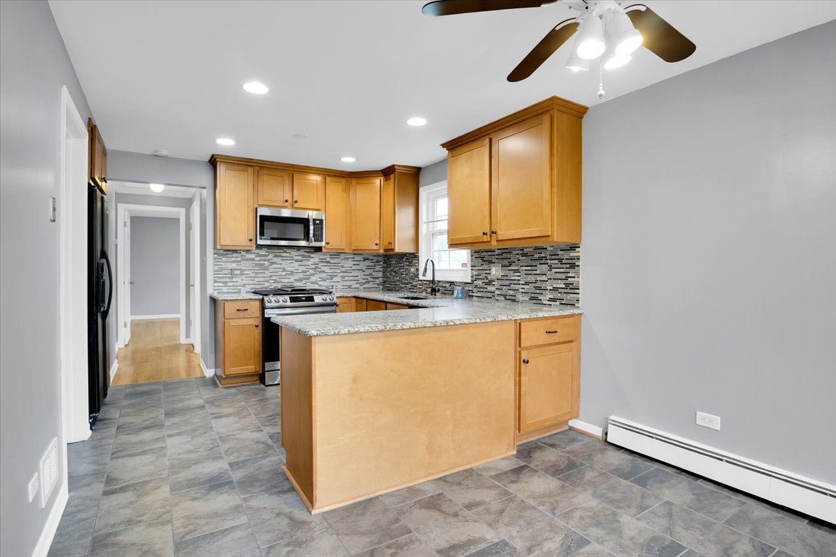 10822 Major Avenue Chicago Ridge, IL 60415 - Photo 18 of 30 a kitchen with stainless steel appliances granite countertop a stove a sink and a refrigerator