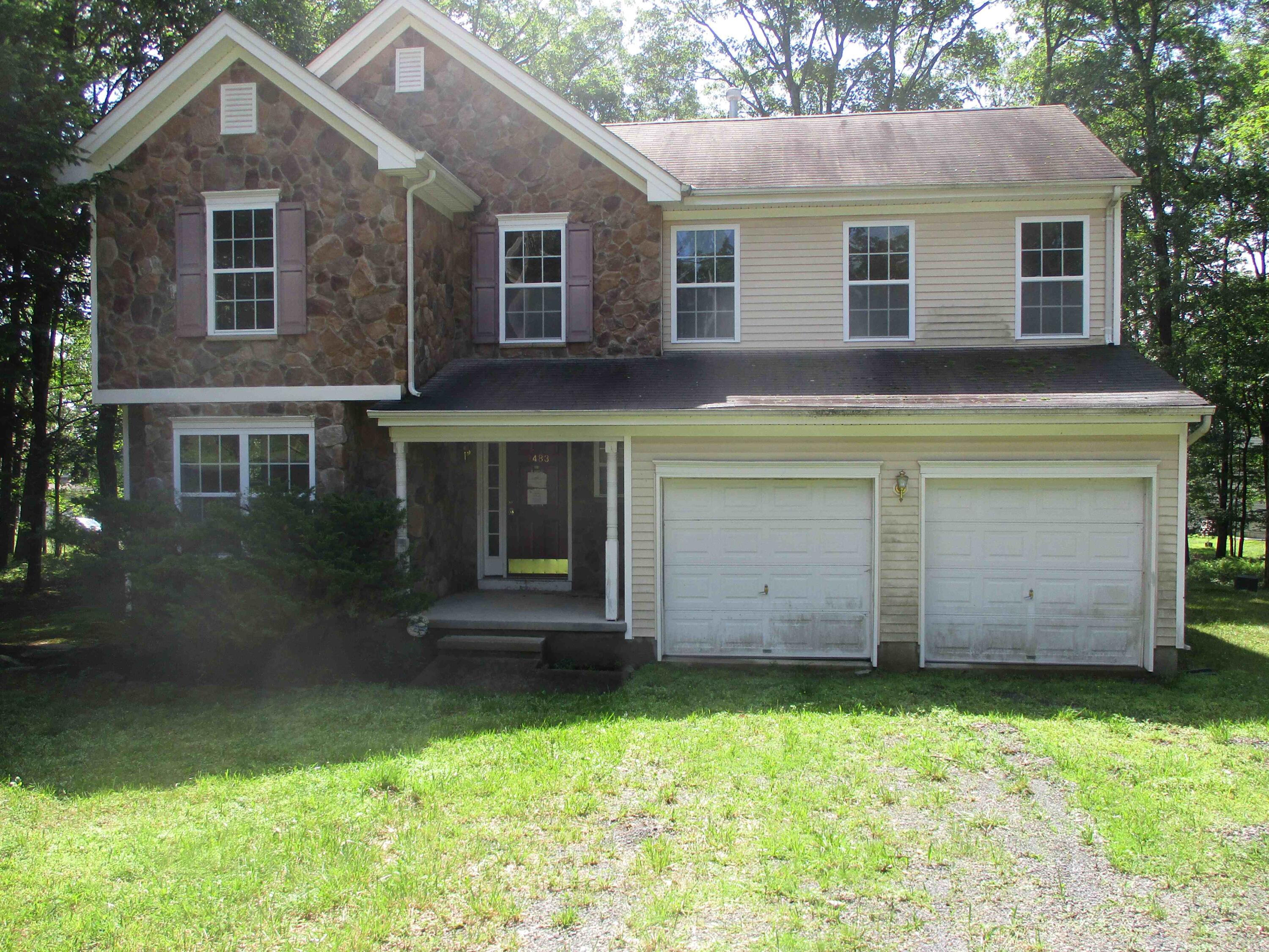 a front view of house with a garden