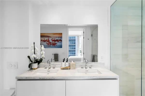 a bathroom with a double vanity sink mirror and shower