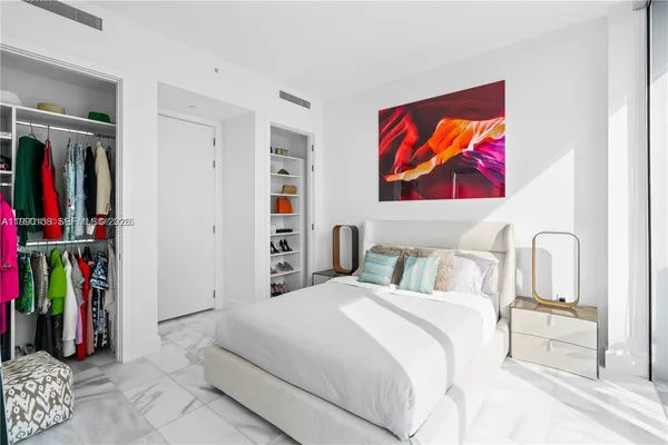 a bedroom with a bed and a painting on the wall