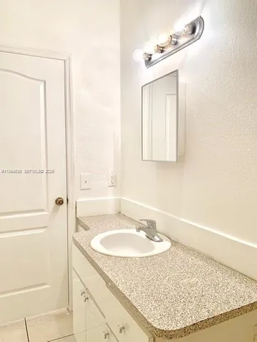a view of a kitchen with a sink and a refrigerator