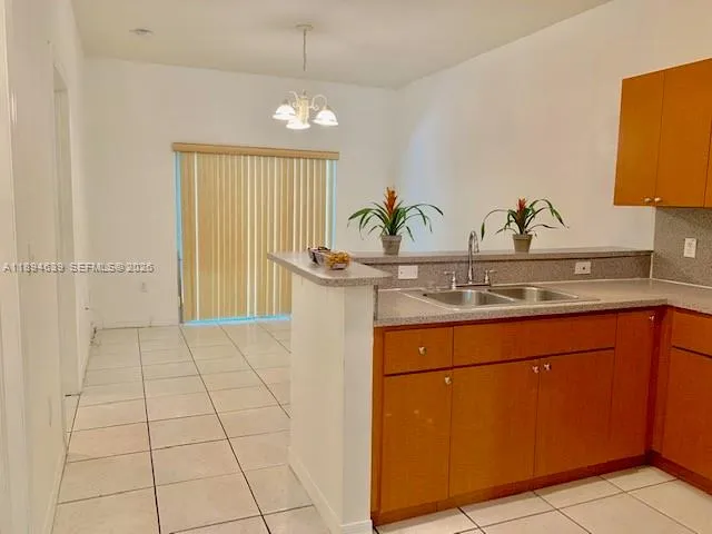 a room with a sink a potted plant and cabinets