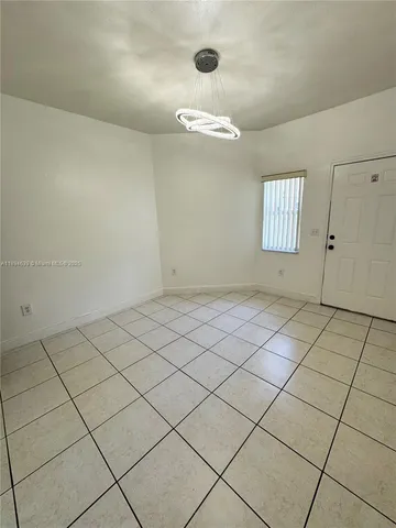 an empty room with windows and white walls