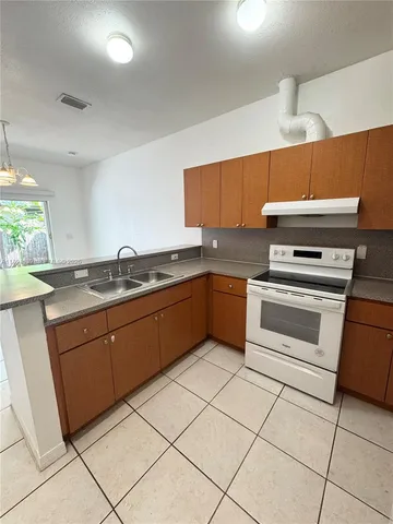 a white refrigerator freezer and a stove sitting inside of a kitchen