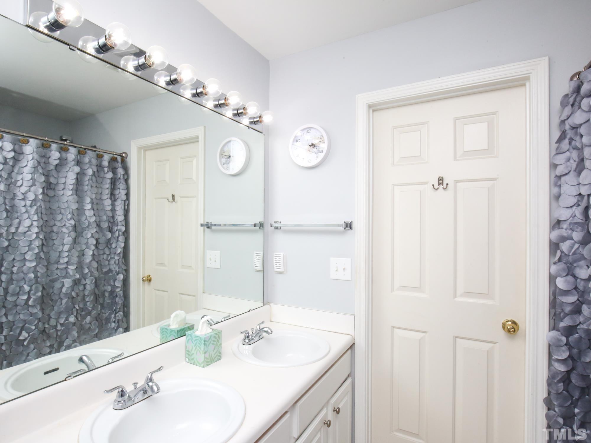 1714 Sorrell Brook Way Raleigh, NC 27609 - Photo 18 of 29 a bathroom with a sink vanity granite shower and a mirror