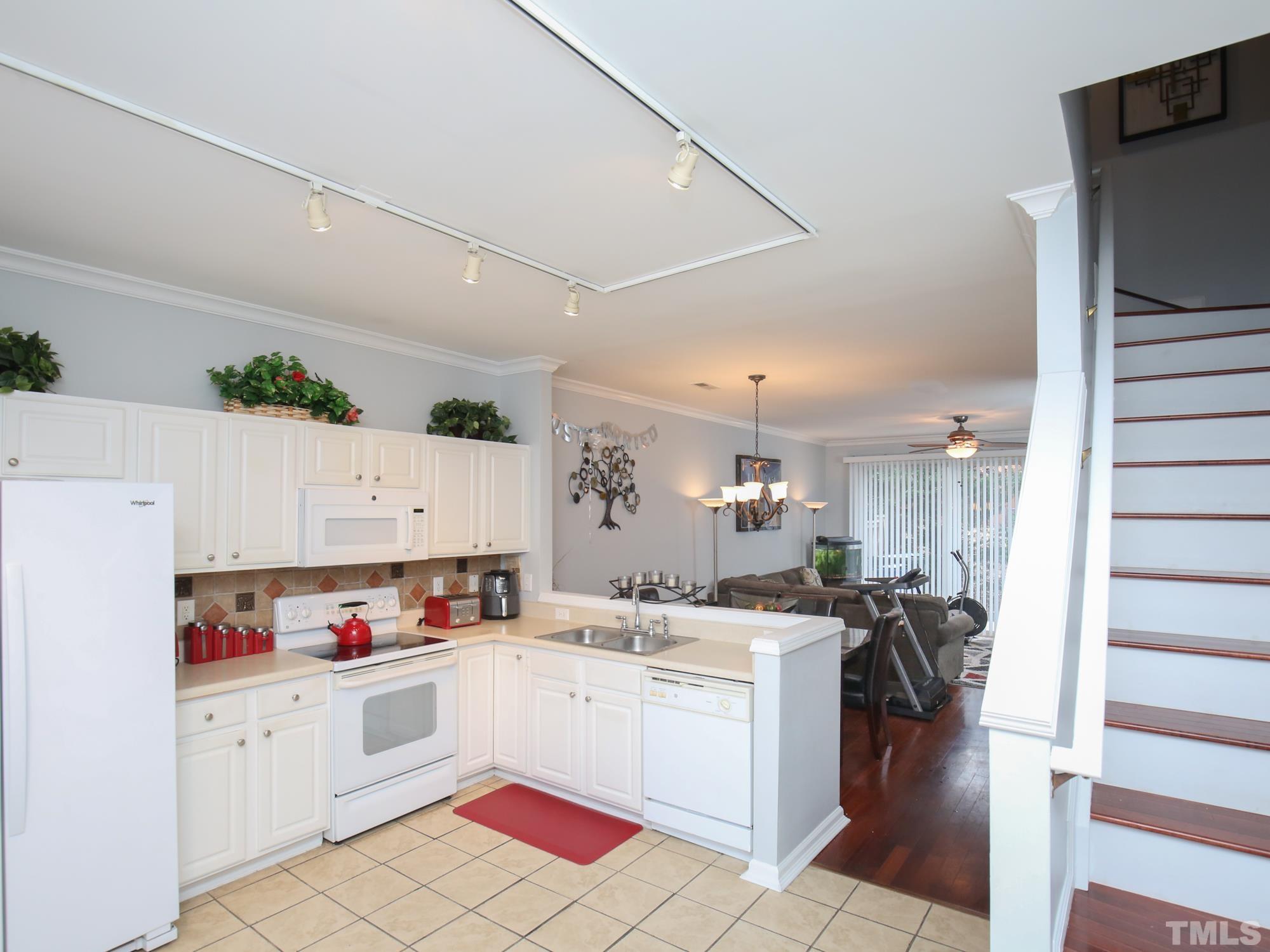 1714 Sorrell Brook Way Raleigh, NC 27609 - Photo 3 of 29 a kitchen with granite countertop a sink stainless steel appliances and white cabinets