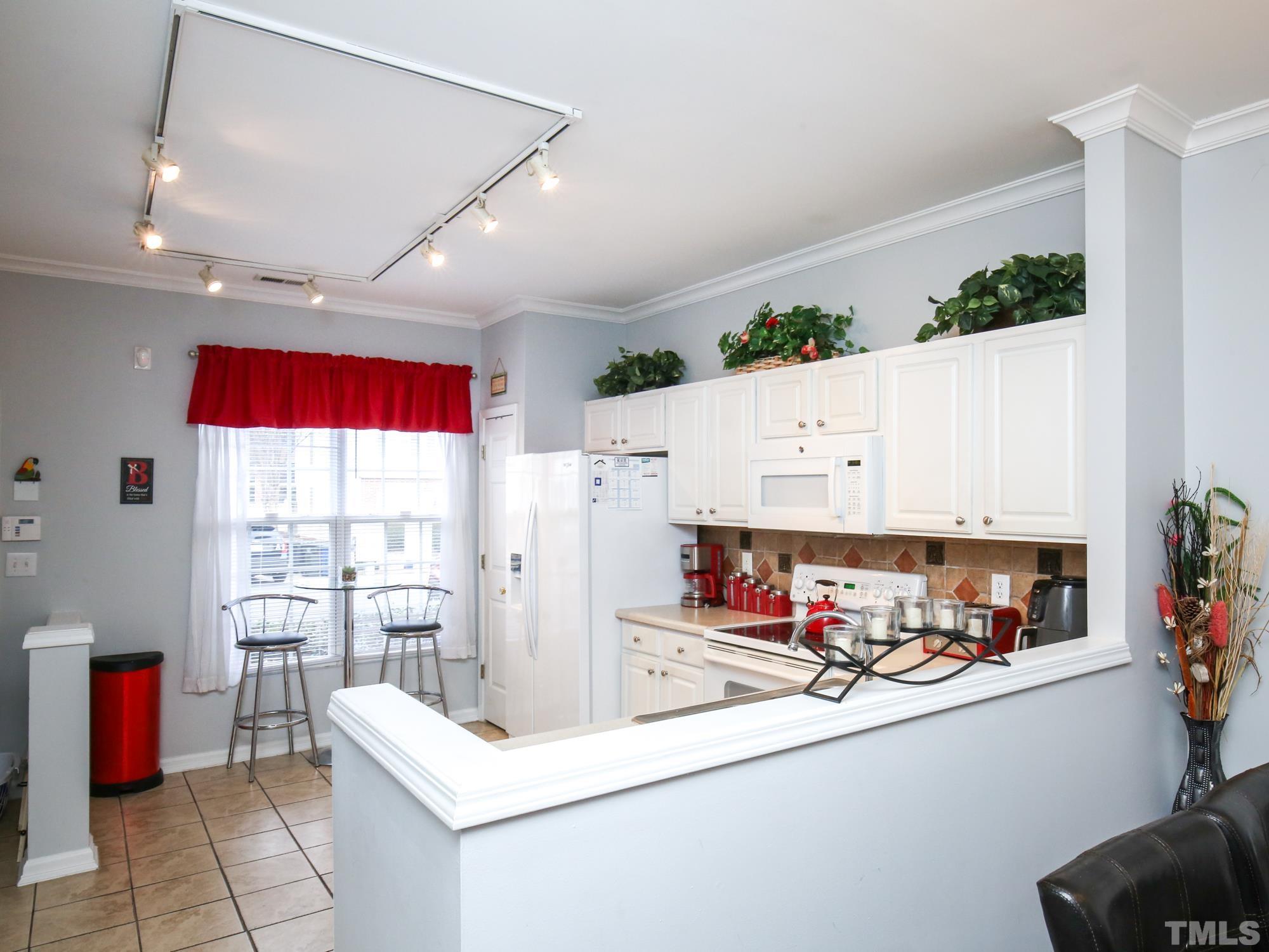 1714 Sorrell Brook Way Raleigh, NC 27609 - Photo 6 of 29 a kitchen with stainless steel appliances kitchen island granite countertop a refrigerator and a stove