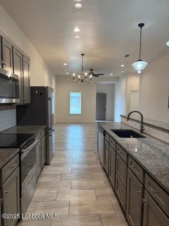 a bathroom with a granite countertop sink a mirror and shower