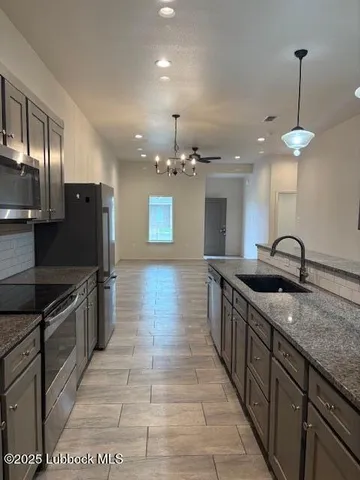 a bathroom with a granite countertop sink a mirror and shower