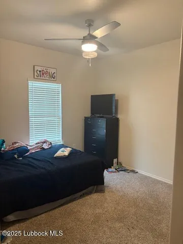 a bedroom with a bed and painting on the wall