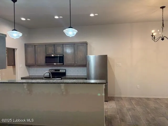 a kitchen with granite countertop a refrigerator and a stove