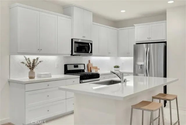 a kitchen with appliances a sink cabinets and a counter top space