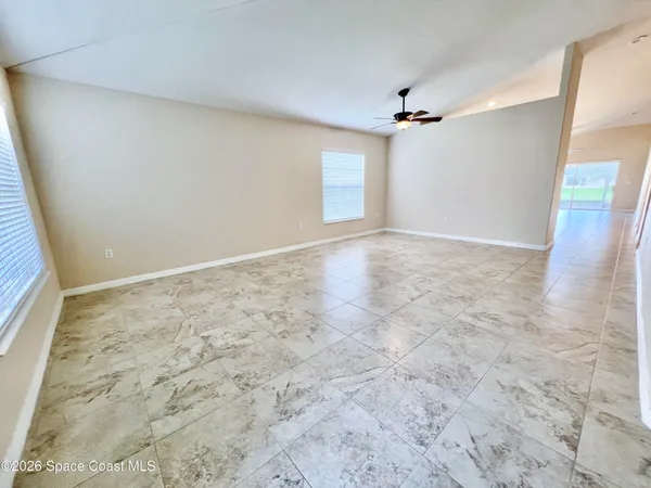an empty room with a windows and ceiling fan