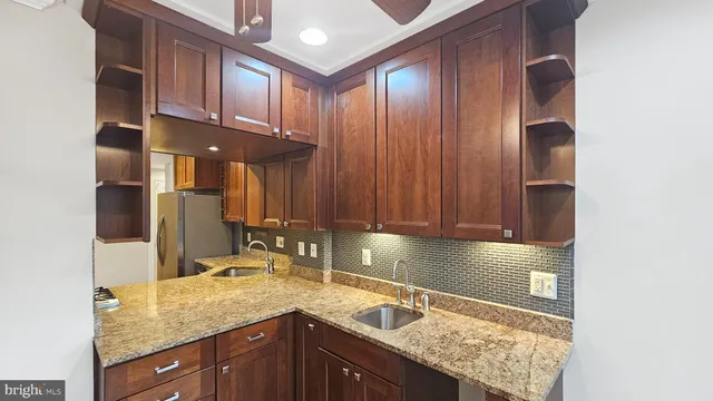 a kitchen with stainless steel appliances granite countertop a sink stove and cabinets