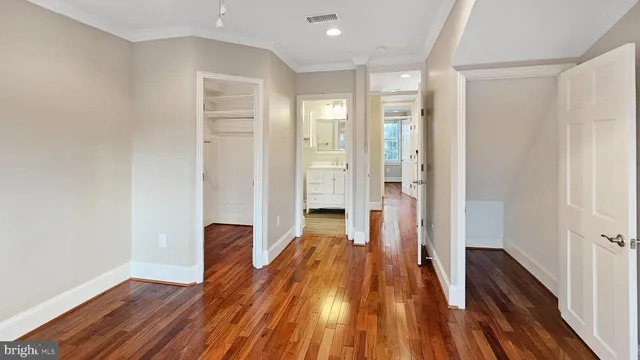 a view of a room with wooden floor and a hallway