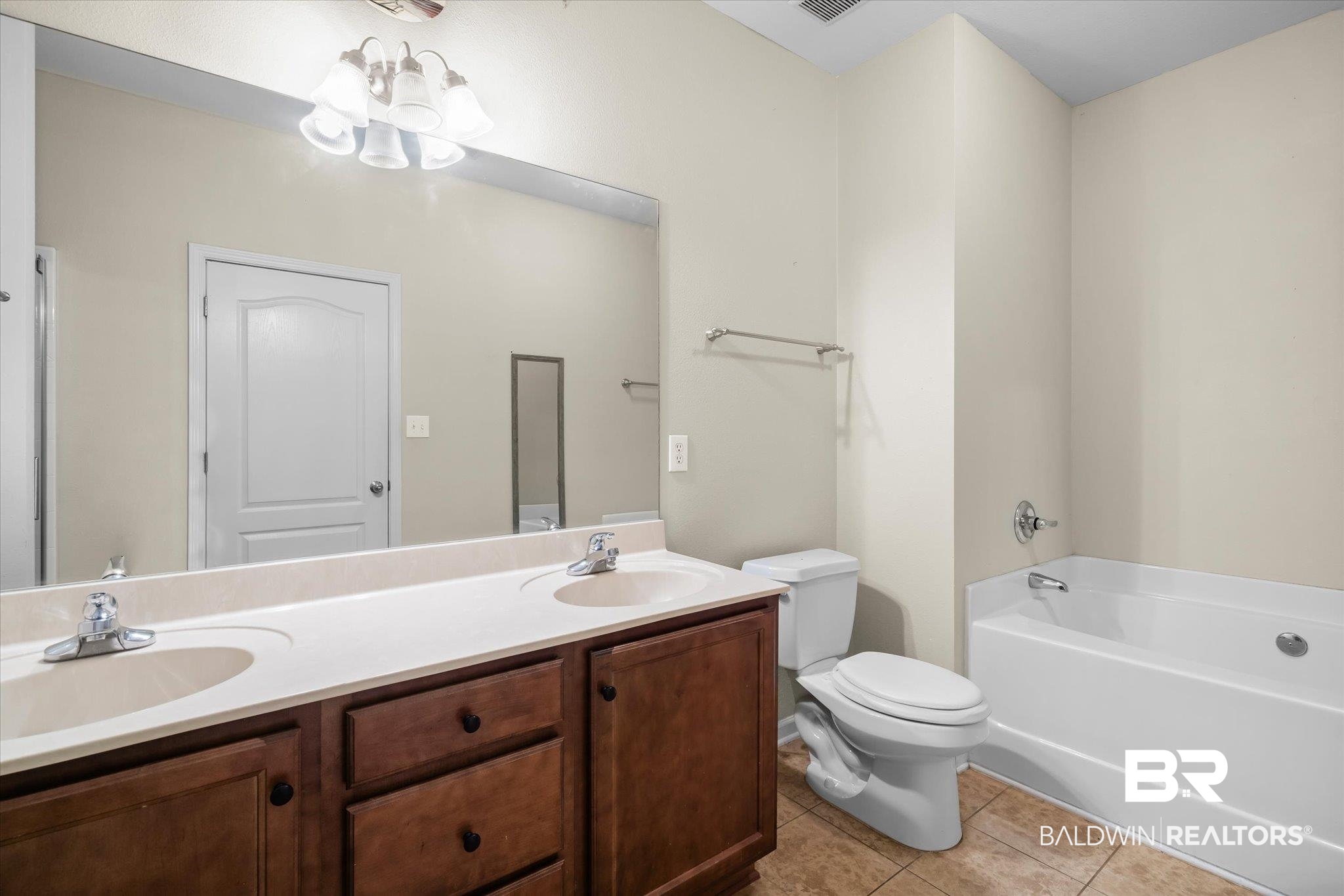 10251 Fionn Loop Daphne, AL 36526 - Photo 13 of 28 Bathroom with tile patterned flooring, a bath, a notable chandelier, toilet, and vanity