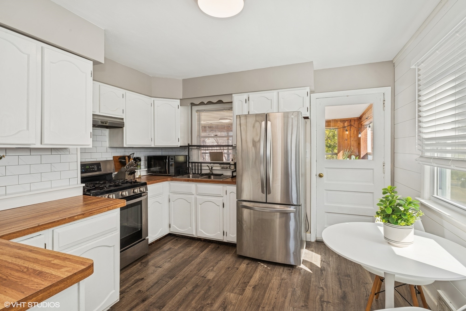5414 Thelen Drive McHenry, IL 60051 - Photo 8 of 18 a kitchen with stainless steel appliances granite countertop a refrigerator a stove a sink dishwasher and white cabinets with wooden floor