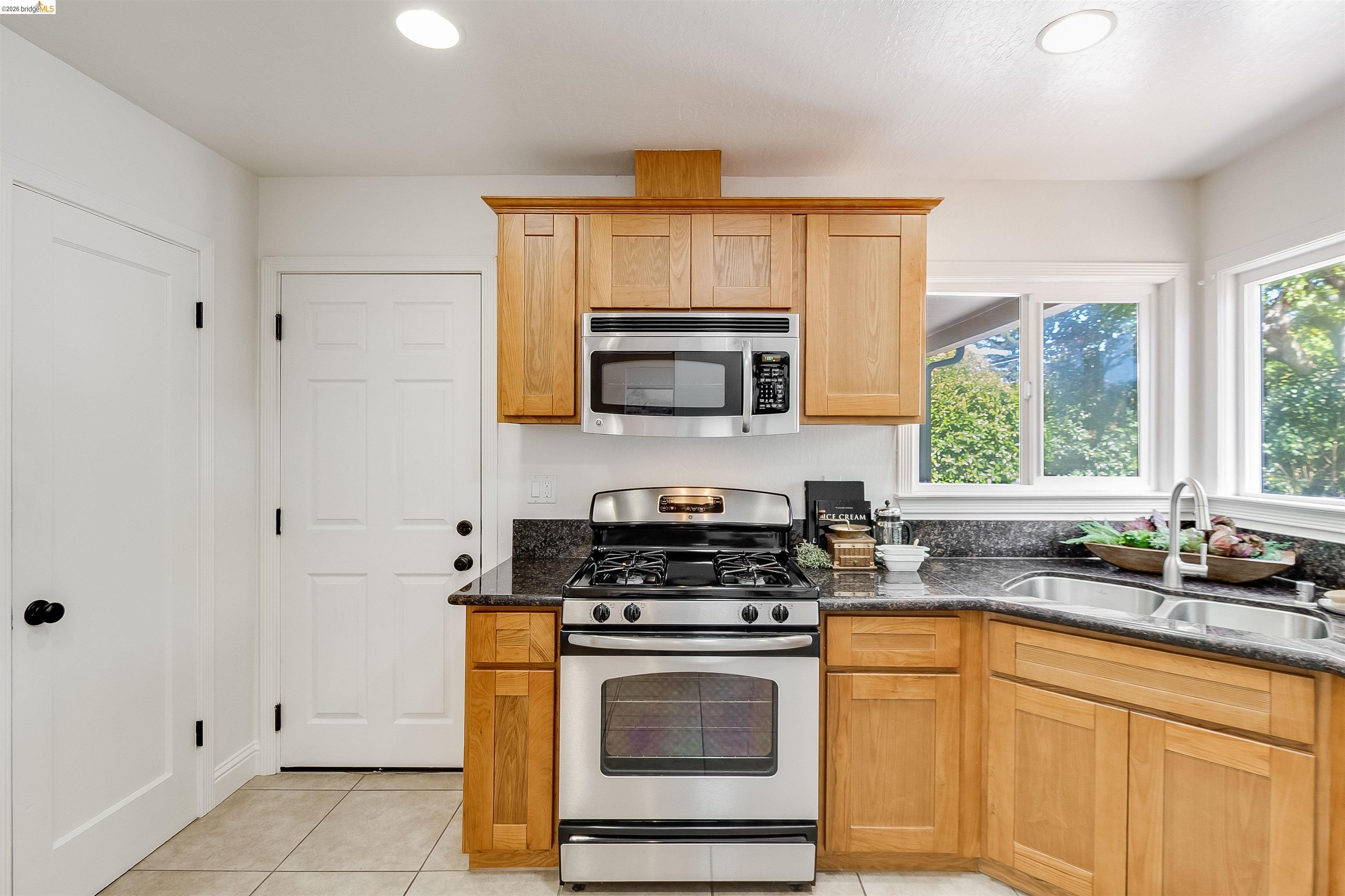 346 Valley View Road Pleasant Hill, CA 94523 - Photo 16 of 57 Kitchen featuring honey-toned cabinetry, stainless steel appliances, dark stone countertops, and a dual basin sink