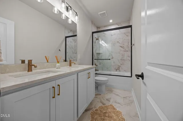 a bathroom with a double vanity sink mirror toilet and next to a window