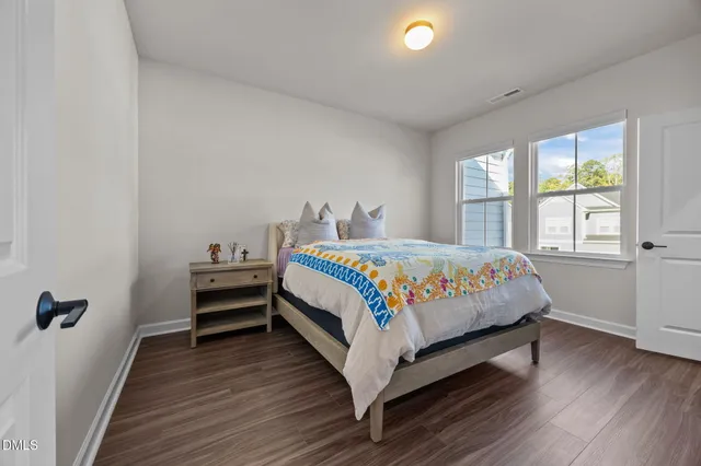 a bed sitting in a bedroom next to a window