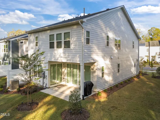 a backyard of a house with yard table and chairs