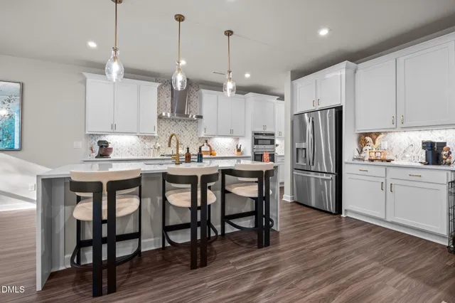 a kitchen with refrigerator cabinets dining table and chairs