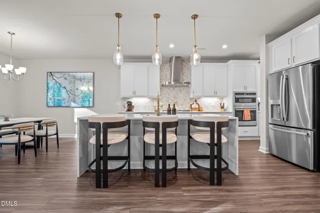 a kitchen with refrigerator dining table and chairs