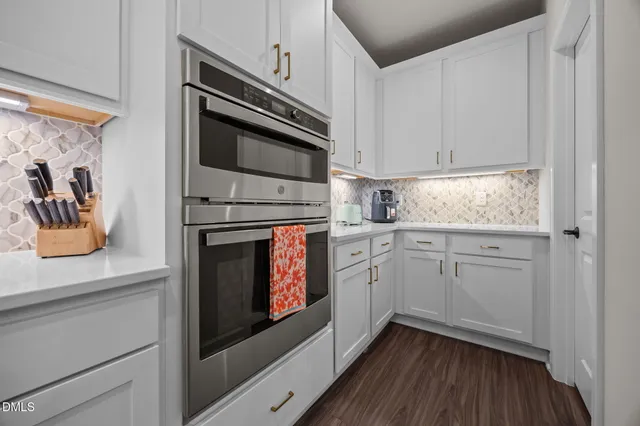 a kitchen with white cabinets and appliances