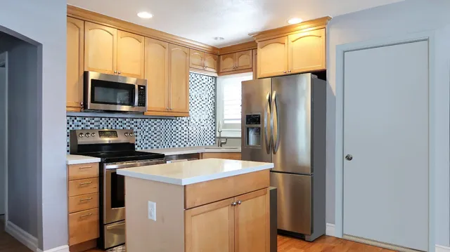 a kitchen with a refrigerator and a stove top oven