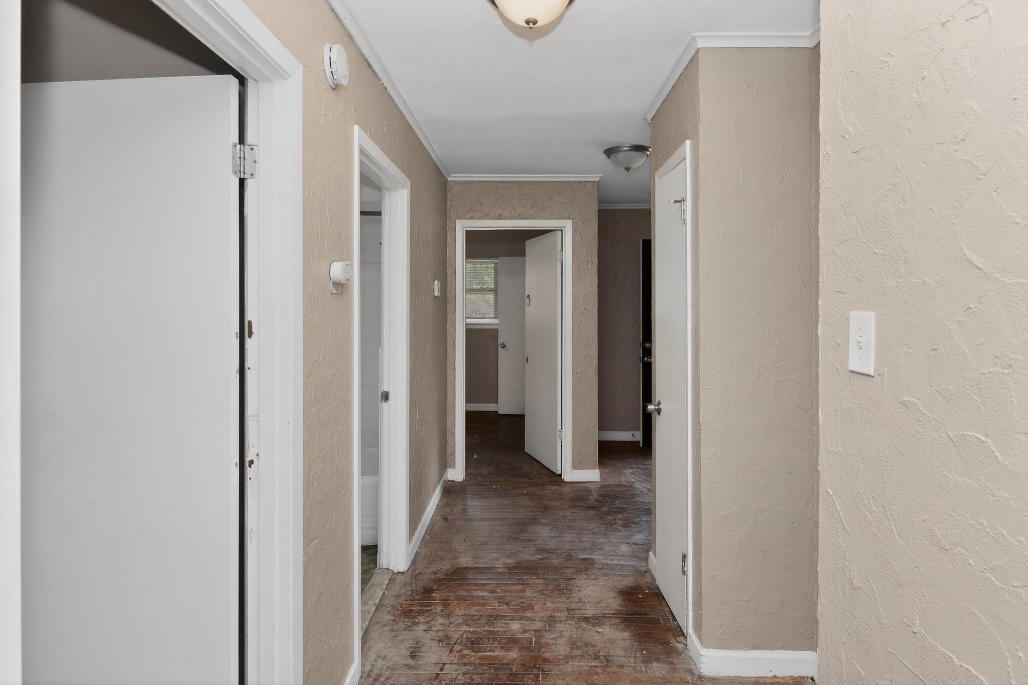 1403 Old Hickory Road Memphis, TN 38116 - Photo 17 of 31 Interior hallway featuring multiple entryways, textured wall finishes, ceiling-mounted lighting, and baseboard trim