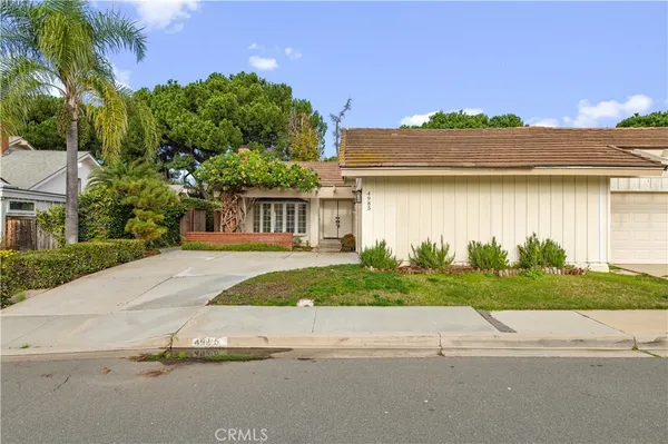 a front view of a house with a yard and potted plants