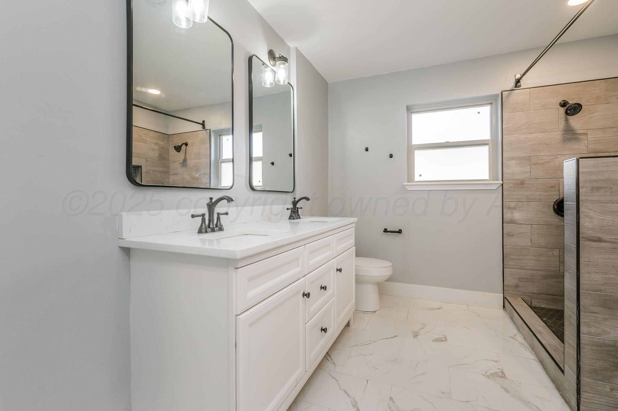 6218 Adirondack Trail Amarillo, TX 79106 - Photo 14 of 26 a bathroom with a double vanity sink and mirror with shower