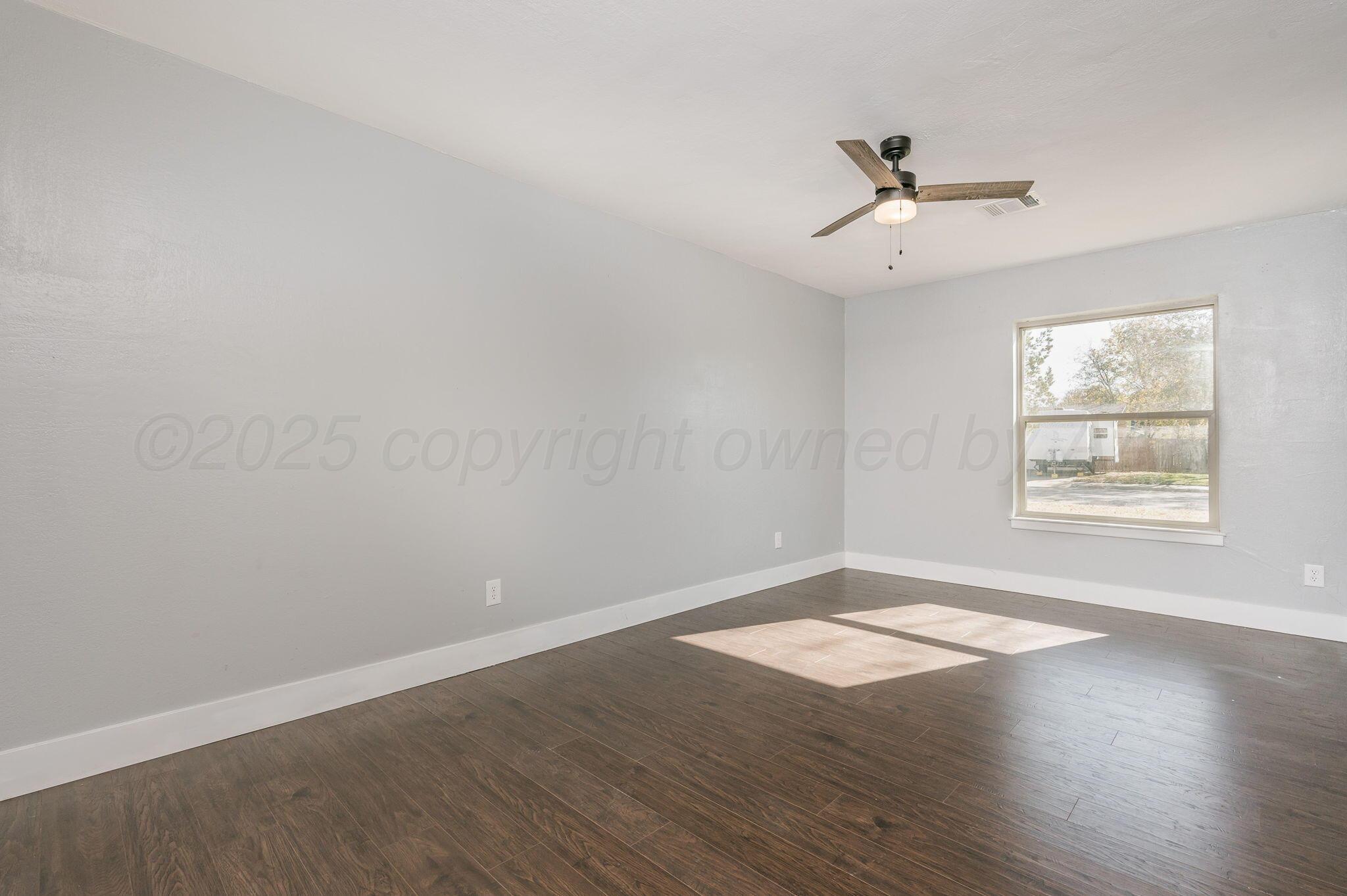 6218 Adirondack Trail Amarillo, TX 79106 - Photo 19 of 26 an empty room with wooden floor fan and windows