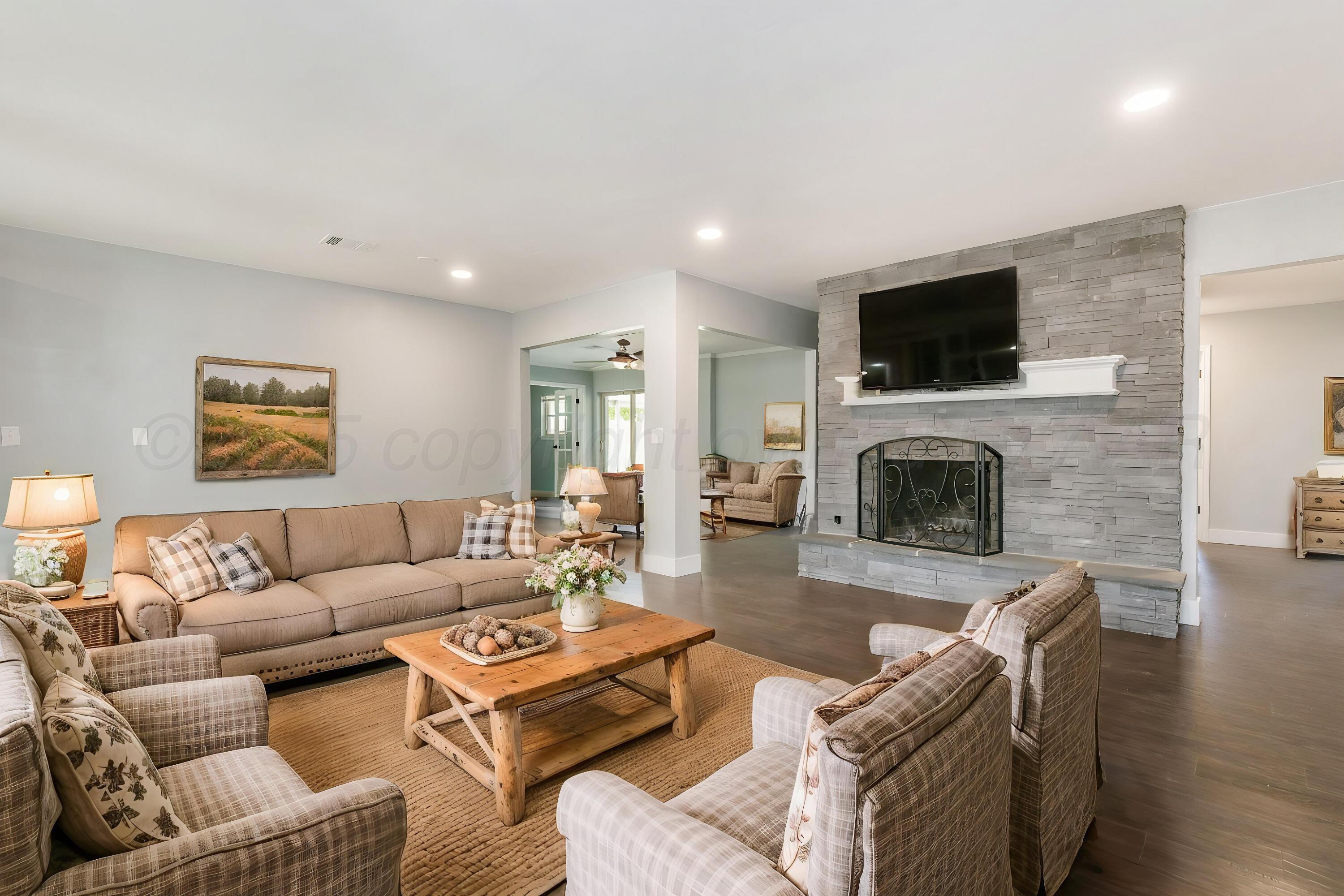 6218 Adirondack Trail Amarillo, TX 79106 - Photo 4 of 26 a living room with furniture a flat screen tv and a fireplace