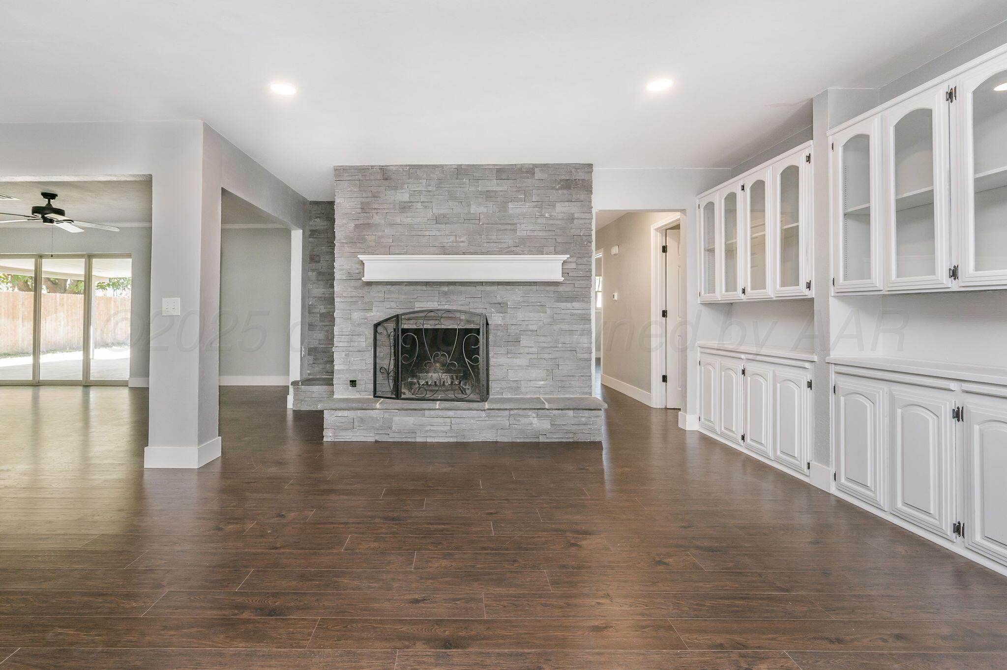 6218 Adirondack Trail Amarillo, TX 79106 - Photo 5 of 26 a view of an empty room with wooden floor and a fireplace