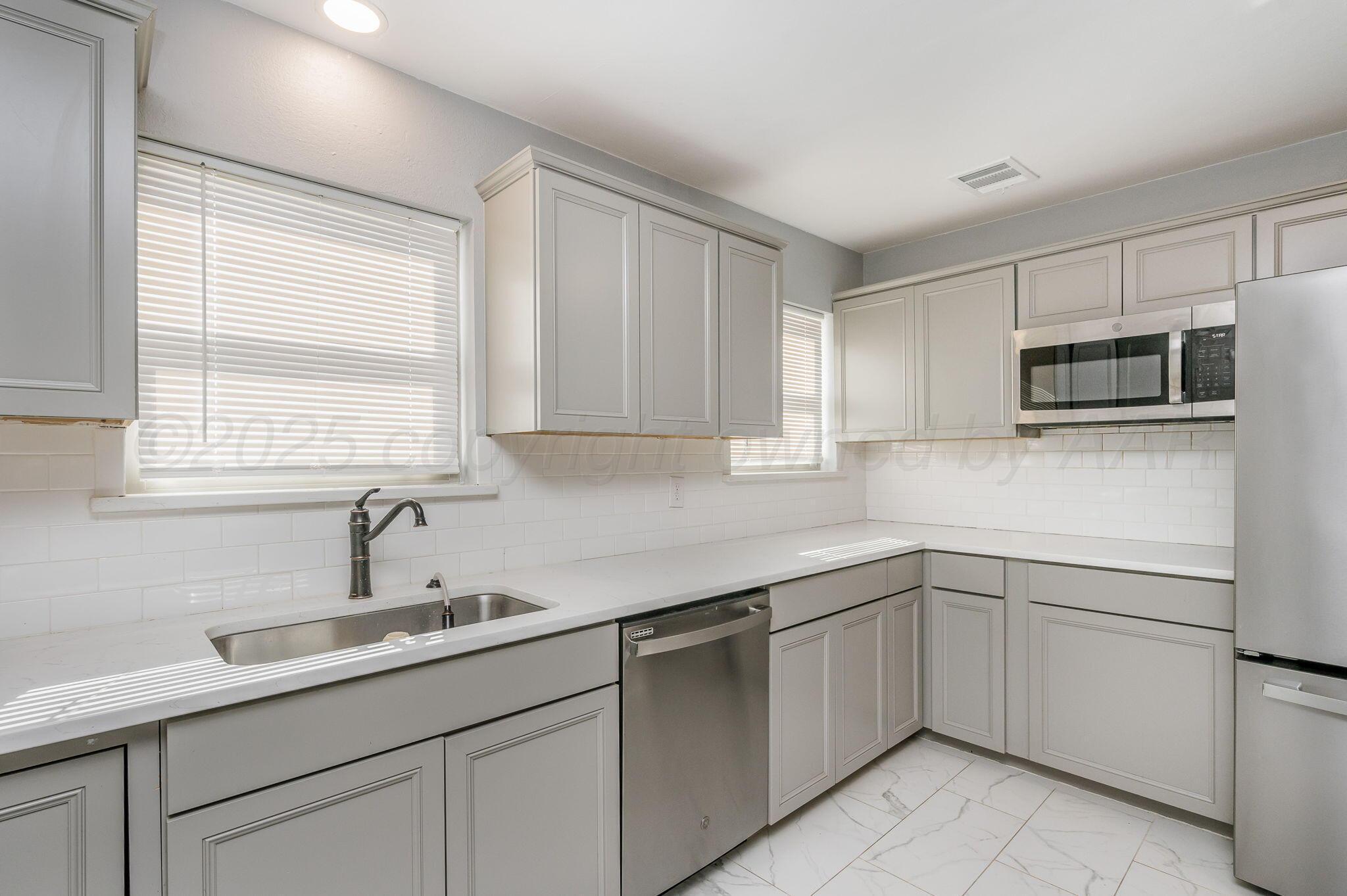 6218 Adirondack Trail Amarillo, TX 79106 - Photo 9 of 26 a kitchen with a sink and cabinets