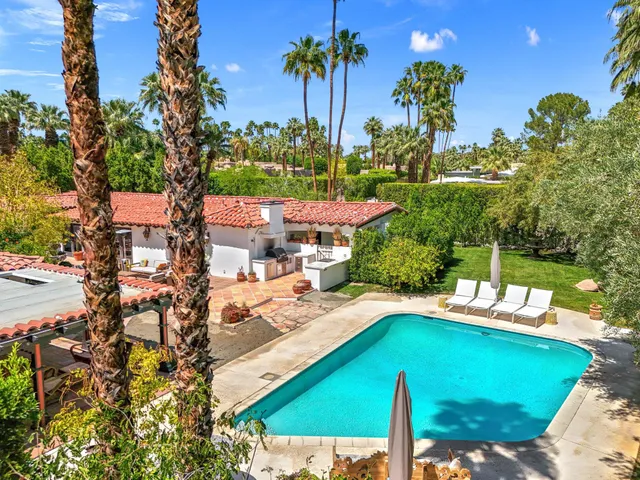 a view of a patio with couches and a table and chairs with wooden floor and fence