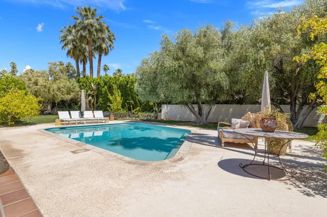a view of a patio with couches table and chairs and potted plants