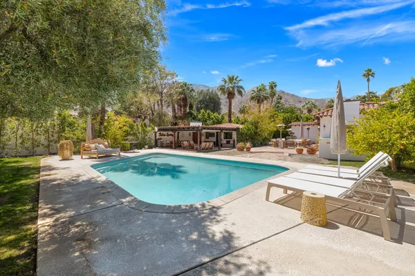 a view of a house with backyard and sitting area