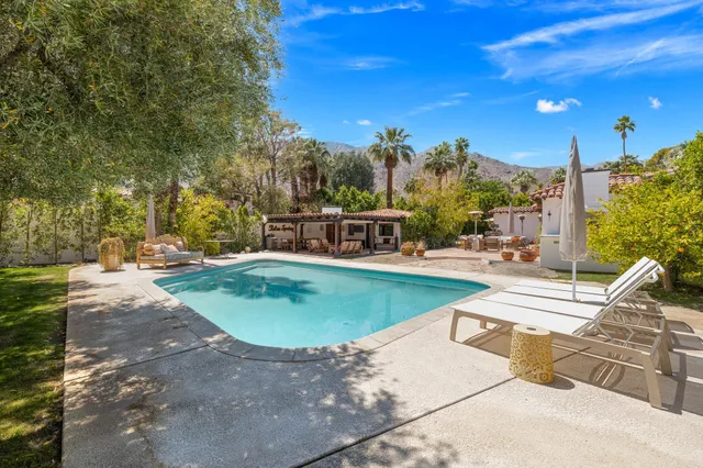 a view of a house with backyard and sitting area
