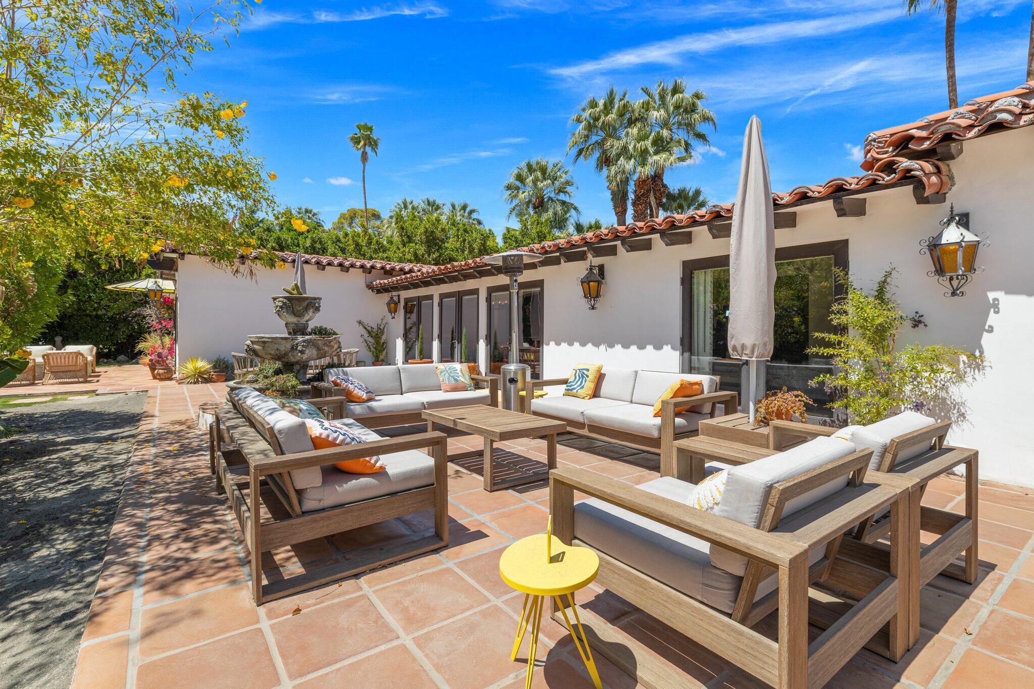 435 West Vereda Sur Palm Springs, CA 92262 - Photo 33 of 80 a view of a patio with couches and table and chairs with potted plants