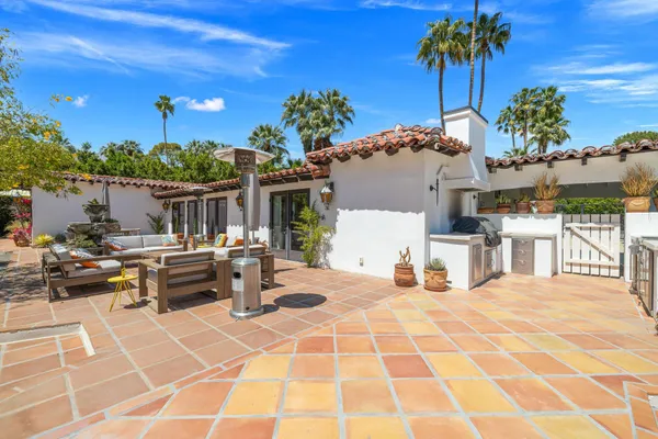 a kitchen with stainless steel appliances granite countertop a stove a sink a oven a dining table and chairs with wooden floor