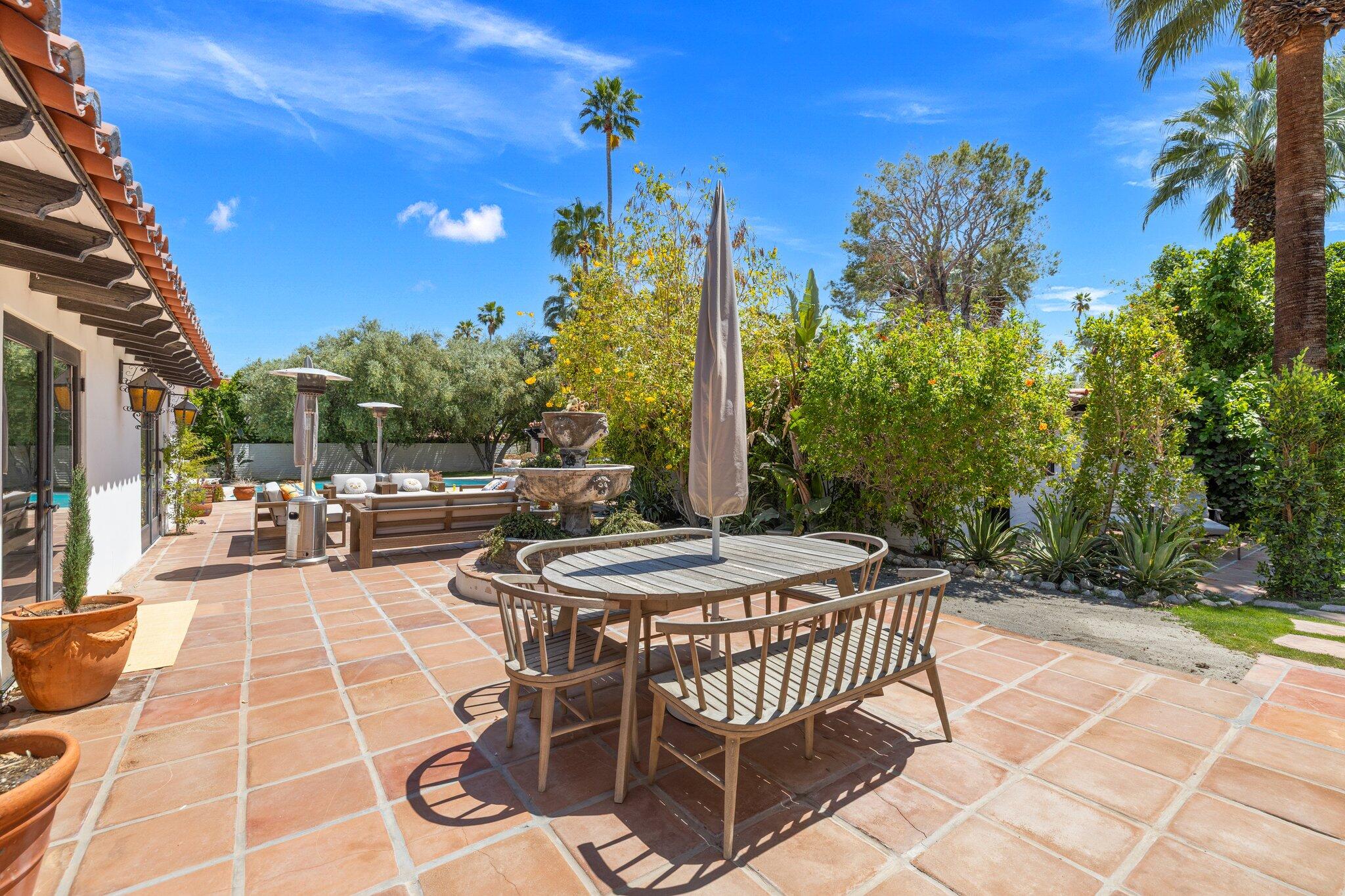 435 West Vereda Sur Palm Springs, CA 92262 - Photo 36 of 80 a view of a patio with a dining table and chairs with wooden floor and fence