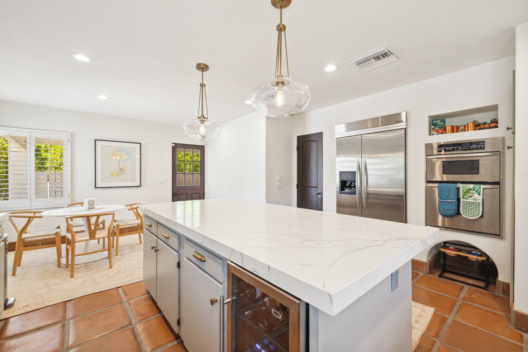 435 West Vereda Sur Palm Springs, CA 92262 - Photo 55 of 80 a large kitchen with granite countertop a stove a sink a dining table and chairs with wooden floor