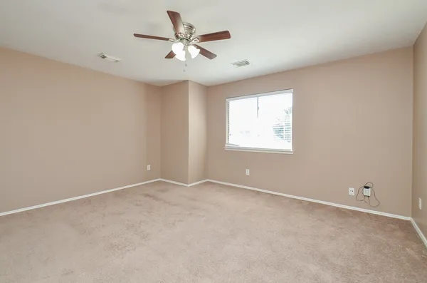 an empty room with windows and fan