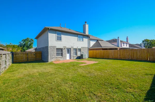 a view of a house with backyard and a tree