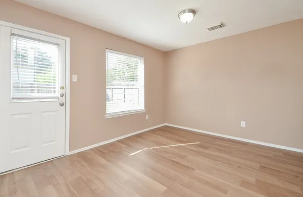 a view of an empty room with a window and fireplace